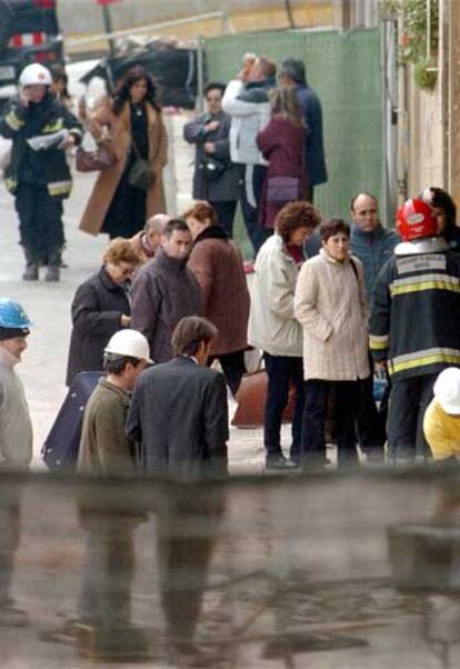 Vecinos de los edificios que van a ser derruidos esperan para poder entrar en sus casas con los bomberos.