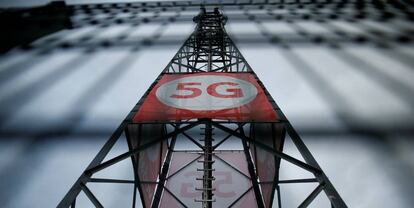 Un cartel con el logotipo de 5G sobre una torre de telefonía móvil de Vodafone en Alemania.  