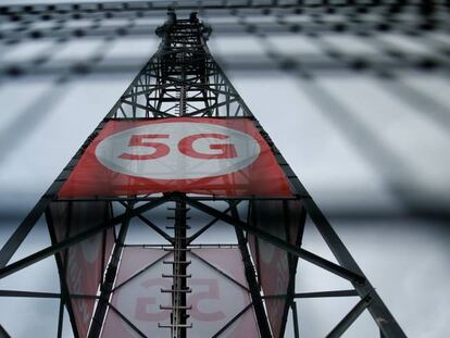 Un cartel con el logotipo de 5G sobre una torre de telefonía móvil de Vodafone en Alemania.  