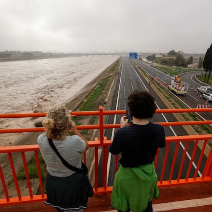 GRAFCVA3848. VALENCIA, 30/10/2024.- Dos personas contemplan el nuevo cauce del Turia repleto de agua a causa de la gota fría que sufre la Comunitat Valenciana, la peor de este siglo XXI, comparable a las vividas en 1987 y en 1982, la de la 'Pantanada de Tous', según el primer balance ofrecido por la Agencia Estatal de Meteorología en su perfil de X. EFE/Biel Aliño