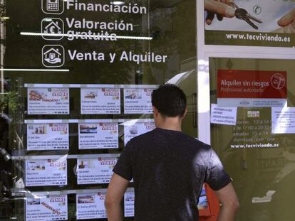 A man checks out house listings at a realtor in Madrid.
