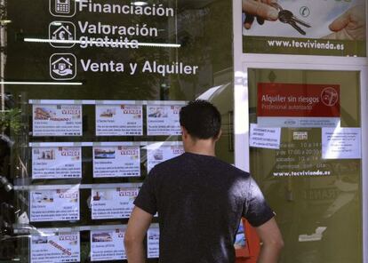 A man checks out house listings at a realtor in Madrid.