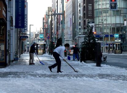 En la prefectura de Ibaraki, al nordeste de Tokio, una mujer de 52 años falleció en la tarde del lunes después de que su vehículo chocara frontalmente con un camión debido al mal estado de la carretera, informó la cadena pública japonesa NHK. En la imagen, residentes quitan la nieve de la acera con la ayuda de unas palas en el distrito de Ginza en Tokio (Japón), el 23 de enero de 2018.