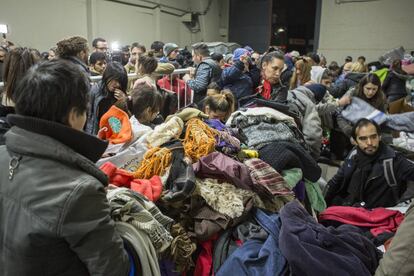 Personas en situación de calle buscan ropa con la que abrigarse entre las donaciones recibidas por River. 