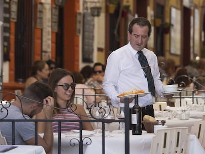 Un camarero atiende una mesa en un restaurante de Ronda (M&aacute;laga).