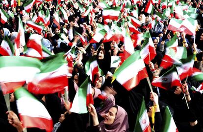 Estudiante iraníes ondean banderas en una ceremonia por el 37º aniversario del triunfo de la Revolución Islámica, en la plaza de Azadi (Libertad) en Teherán.