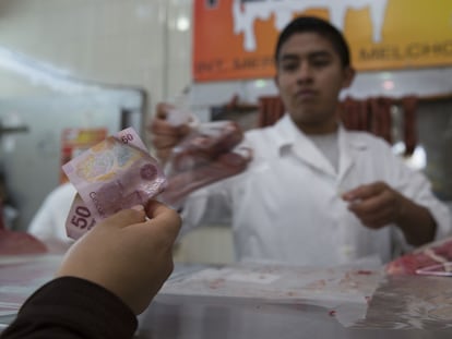 Un cliente paga sus compras en el mercado de Medellín, en Ciudad de México.