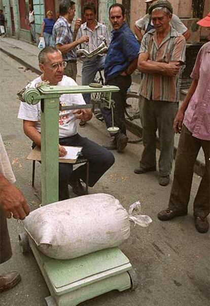 Un hombre pesa un saco de cereal en una calle de La Habana Vieja.