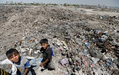 Dos niños recolectan materiales reciclables en un basurero de Bagdad (Irak).