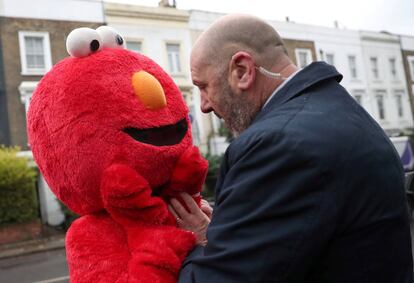 Un miembro de seguridad de Jeremy Corbyn impide el paso a una persona disfrazada de Elmo, un personaje de Barrio Sésamo, en el colegio electoral donde votaba el líder del Partido Laborista.