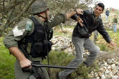 Un policía israelí detiene ayer a un joven palestino en una zona fronteriza de Gaza.