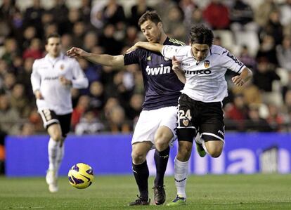Xabi Alonso pelea un balón con el centrocampista argentino del Valencia, tino Costa.