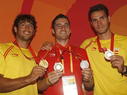 Los integrantes del K-2 (oro), Carlos Pérez, a la izquierda, y Saúl Craviotto flanquean a David Cal (plata en k-1) mostrando sus medallas.