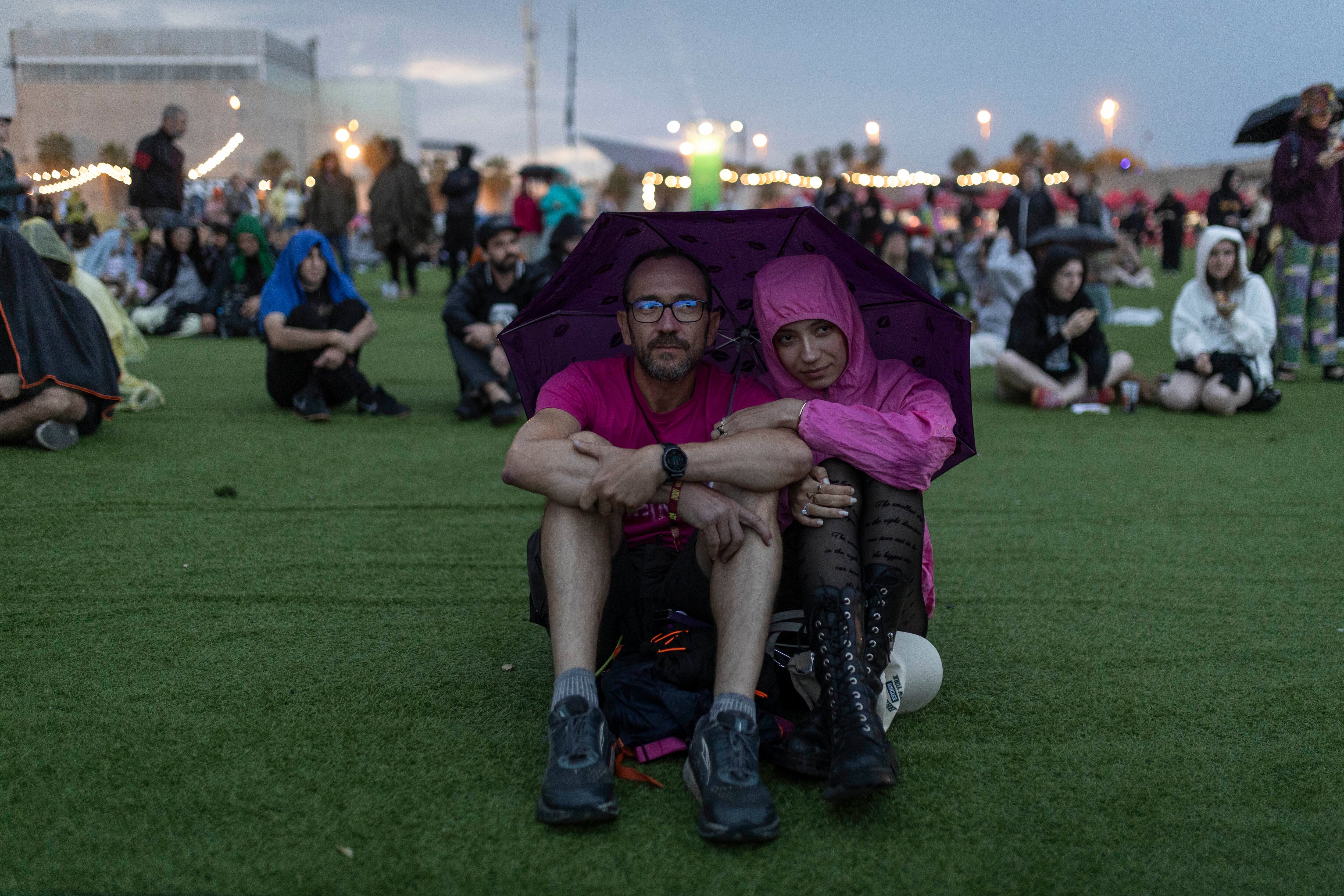 Una pareja siguen bajo el concierto de PJ Harvey bajo un paraguas, el 1 de junio.