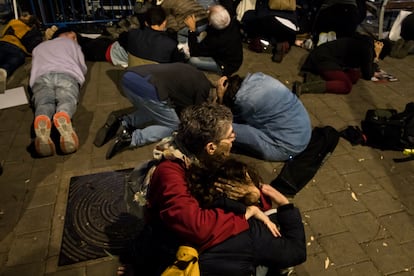 La gente se cubre mientras se escucha la sirena que avisa de la caída de cohetes sobre Tel Aviv, durante una manifestación de familiares de rehenes. 