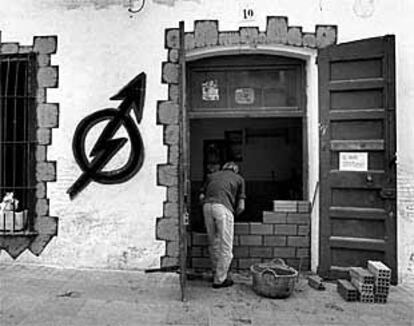 Una persona tapia la entrada de una casa, en Vilassar de Mar, después de un desalojo.