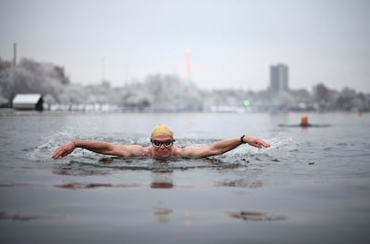Un hombre nada en el lago Sepertine de Londres. Los termómetros marcan en esta jornada de nieve mínimas de - 2 grados y máximas de 2. 
