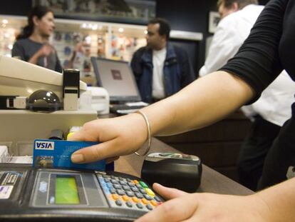 Una mujer cobra a un cliente con su tarjeta Visa.