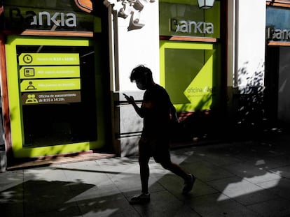 MADRID, 04/09/2020.- Una persona camina por el centro de Madrid delante de una sucursal de Bankia.