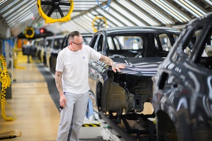 Un trabajador de Volkswagen verifica la pintura de un VW Tayron, en la planta alemana de Wolfsburgo.