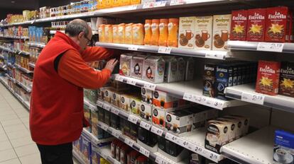 Un empleado coloca productos en un supermercado.