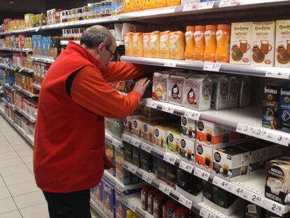 Un empleado coloca productos en un supermercado.