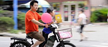 Un hombre conduce un ciclomotor eléctrico en China.