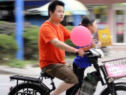 Un hombre conduce un ciclomotor el&eacute;ctrico en China. 