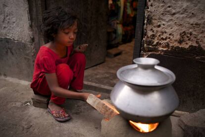 Bithi, de 12 años, prepara la comida para toda su familia en un slum de Dacca, Bangladesh.