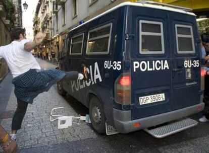 Varios jóvenes golpean el vehículo policial en el que fue trasladado Joseba Álvarez tras ser detenido cerca de su domicilio, en San Sebastián.