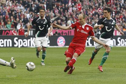 Robben dispara ante la mirada de dos rivales del Hannover.