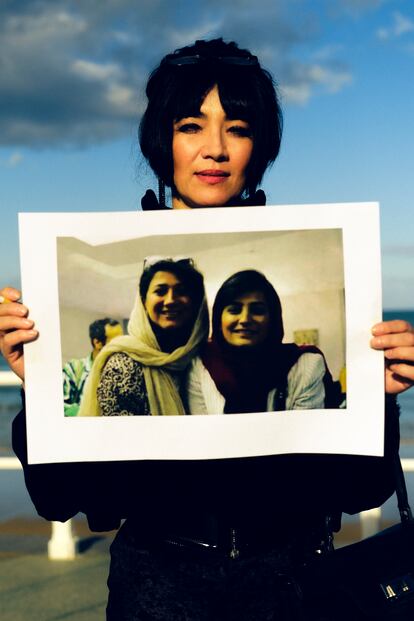 Farahani sostiene un cartel con la foto de las periodistas iraníes represaliadas Niloofar Hamedi y Elaheh Mohammadi.