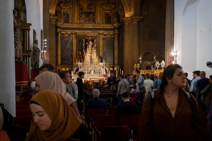 Turistas durante una visita a la iglesia de la Anunciación en Sevilla, con los pasos preparados para salir esta Semana Santa.