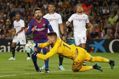 Vaclik, portero del Sevilla, bloca el balón ante Piqué.