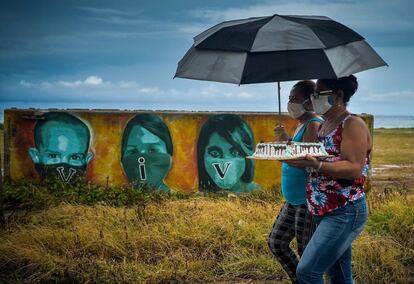 Dos mujeres llevan un pastel en La Habana (Cuba). El país inició esta semana con 52 nuevos contagios de covid-19, la mayoría en la provincia occidental de Pinar del Río, donde se concentra actualmente la segunda ola de la pandemia en la isla.