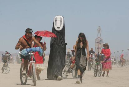 Asistentes al Burning Man caminan por Black Rock Desert.