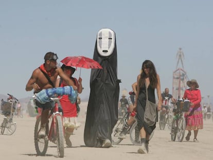 Asistentes al Burning Man caminan por Black Rock Desert.