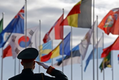 Un soldado ruso, saluda delante de las banderas, durante la ceremonia de bienvenida para el equipo olímpico de EE.UU. en la Villa Olímpica antes de los Juegos Olímpicos de Invierno de 2014 en Sochi.