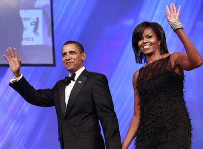 Barack Obama y su esposa Michelle caminan de la mano.