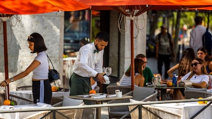 Un camarero atiende una terraza de un bar de Madrid. 