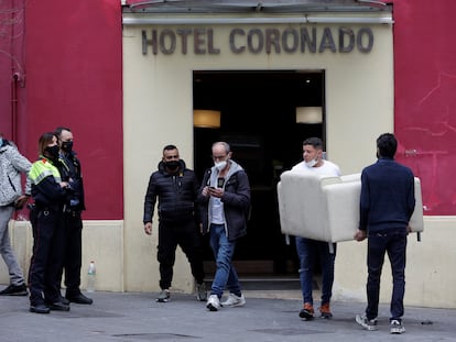 Trabajadores del hotel sacan un sofá de dentro del establecimiento