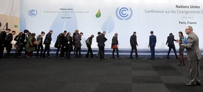 Los delegados buscan los lugares donde los jefes de Estado y de Gobierno se pondrán para la foto de familia durante la cumbre del clima de París.