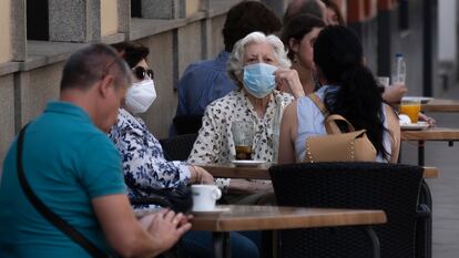 Patrons with masks sit at a street café in Seville, southern Spain on Wednesday