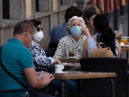 Patrons with masks sit at a street café in Seville, southern Spain on Wednesday