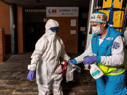 Miembros del equipo sanitario del Summa realizan el proceso de colocación y retiro de un EPI, durante su guardia de 24 horas en el centro de salud Las Águilas, en Madrid.