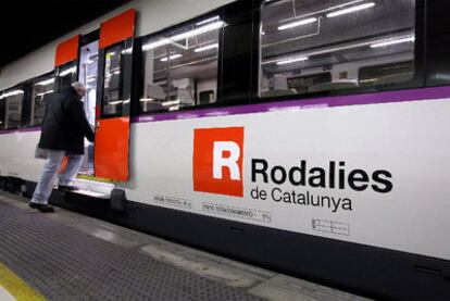 Un viajero sube en la estación de Sants a un tren de cercanías de la Generalitat de Cataluña.