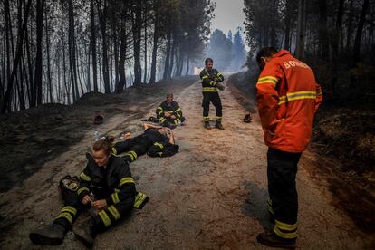 Los bomberos descansan durante una operación para detener un incendio forestal en el pueblo de Sameiro, cerca de la ciudad de Manteigas (Portugal), el jueves.