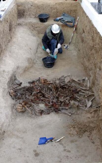 Un aqueólogo, en la fosa junto a los restos de las '17 rosas de Guillena'.