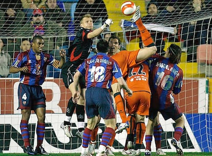 El portero del Levante, Kujovic, despeja ante el acoso de varios jugadores de Osasuna.