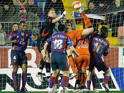 El portero del Levante, Kujovic, despeja ante el acoso de varios jugadores de Osasuna.
